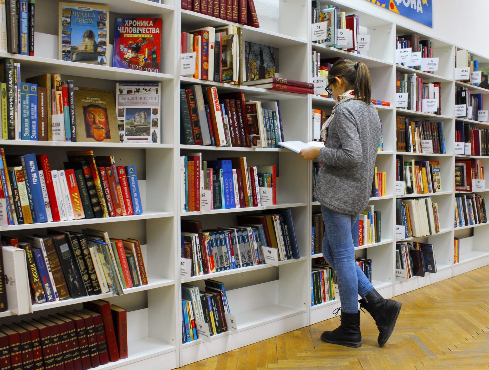 Woman checking modern store book stacks